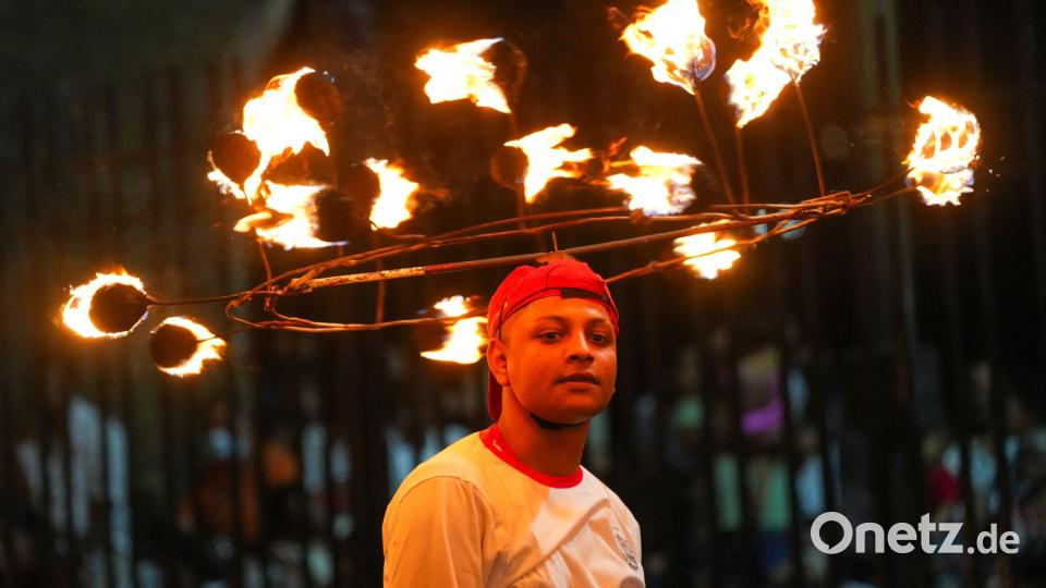 Mit Feuer auf dem Kopf: Ein Darsteller nimmt bei einer Prozession zum Esala-Perahera-Fest teil. Bild: Thilina Kaluthotage/XinHua/dpa