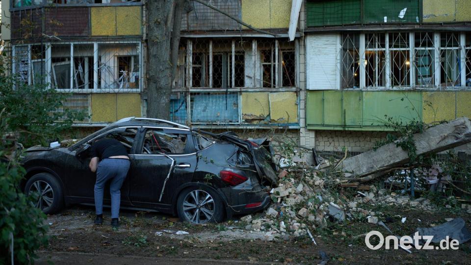 Ein Anwohner blickt nach einem nächtlichen russischen Angriff in ein zerstörtes Auto. Bild: Francisco Seco/AP/dpa