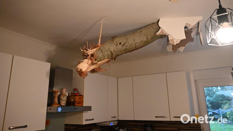 Ein Baumstamm ragt nach einem Unwetter in Fürstenwalde-Süd aus der Decke in der Küche eines Wohnhauses. Bild: Sappeck/BLP/dpa