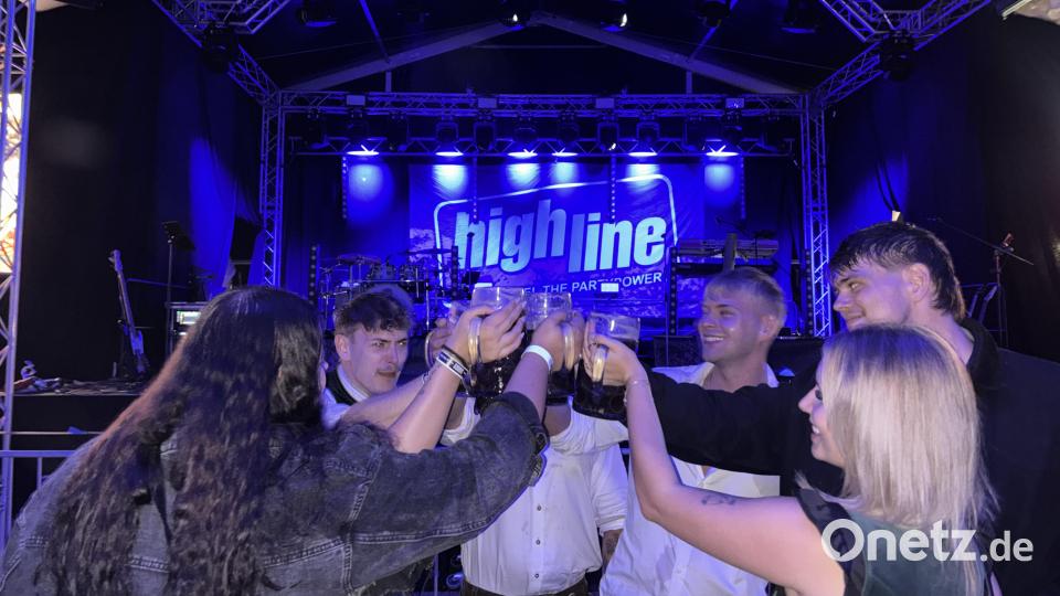 Gäste stoßen am Freitagabend vor der Bühne an. An diesem Abend sorgt die Band „Highline“ für beste Stimmung. Bild: mcl