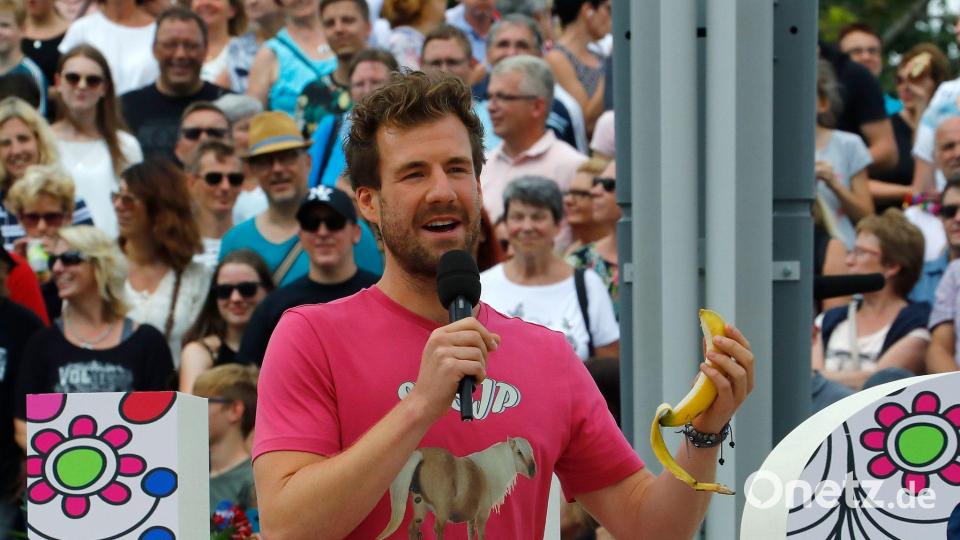 Comedian Luke Mockridge „telefoniert“ mit einer Banane in der Hand auf der Bühne des „ZDF-Fernsehgarten“. (Archivbild) Bild: Ralph Orlowski/ZDF/dpa