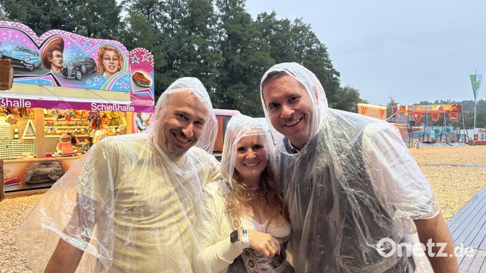 Besucher tragen Ponchos, um sich beim Anstehen vor dem Regen zu schützen. Bild: mcl