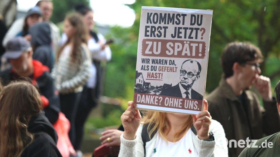 Demonstranten warfen Merz vor, erst nach Ende der Löscharbeiten den Brandort aufzusuchen. Bild: Christoph Reichwein/dpa