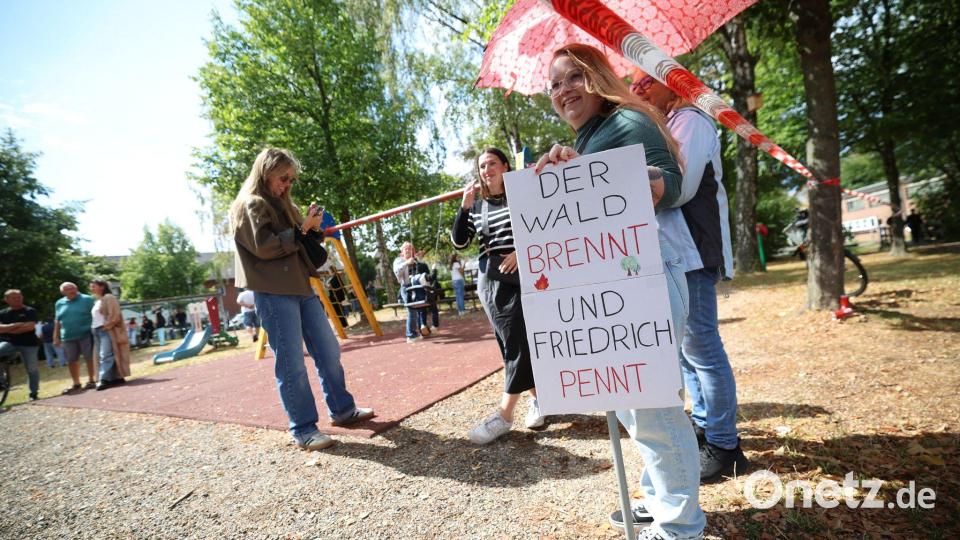 Demonstranten protestierten unter anderem mit einem Plakat, auf dem „Der Wald brennt und Friedrich pennt“ stand. Bild: Christoph Reichwein/dpa
