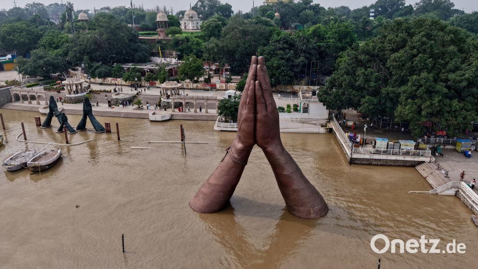 Am Namo Ghat am Ufer des Ganges in Varanasi ragen die Hände einer riesigen Skulptur aus dem Wasser. Der Wasserstand ist nach den Monsunregenfällen angestiegen. Bild: Rajesh Kumar Singh/AP/dpa