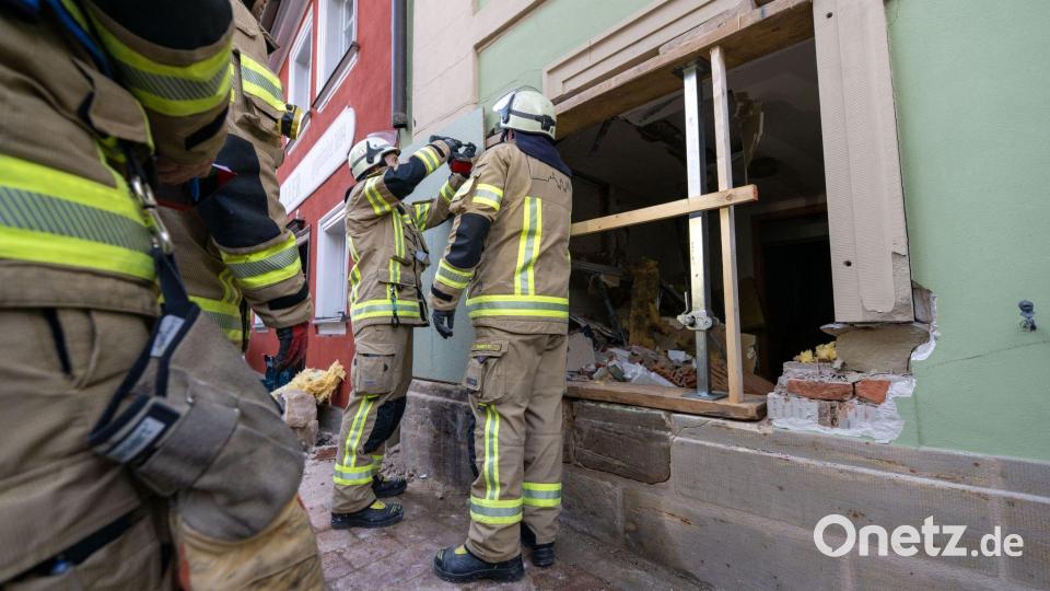 Einsatzkräfte der Feuerwehr sichern die Wand, in der ein großes Loch klafft. Bild: Pia Bayer/dpa