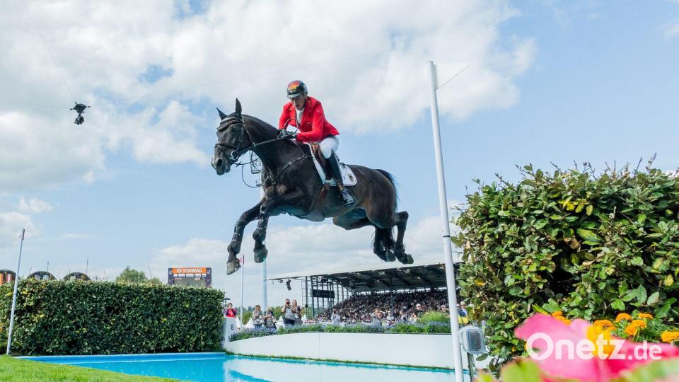 Daniel Deußer springt mit Otello über den Wassergraben. Bild: Rolf Vennenbernd/dpa
