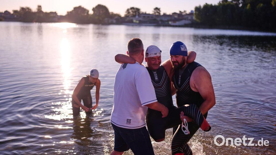 Dem ukrainischen Kriegsveteranen Oleksii Kozak wird bei einer Sportveranstaltung am Rande von Kiew geholfen, aus dem Wasser zu steigen. Bild: Francisco Seco/AP/dpa