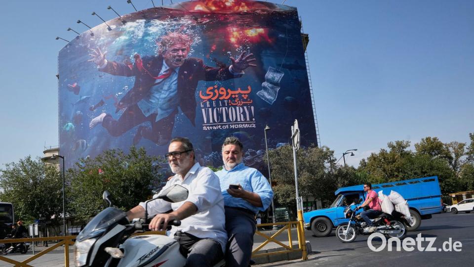 Unter Wasser inmitten von Explosionen: US-Präsident Trump ist auf einer Plakatwand im Iran zu sehen. Bild: Vahid Salemi/AP/dpa