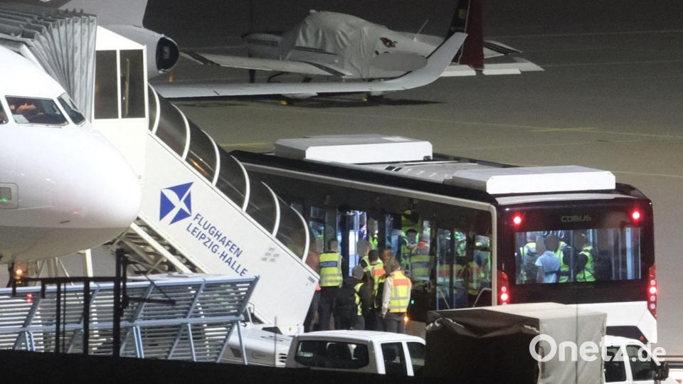 Mit einem Bus wurden die Männer zum Flugzeug gebracht. Bild: Sebastian Willnow/dpa