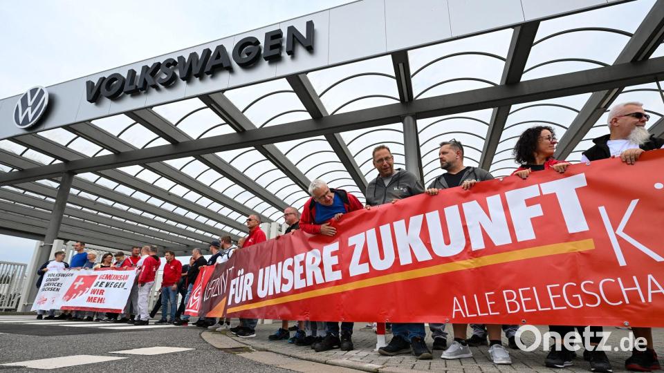 Vor der Betriebsversammlung von VW in Zwickau demonstrieren Beschäftigte am Werkstor. Bild: Hendrik Schmidt/dpa