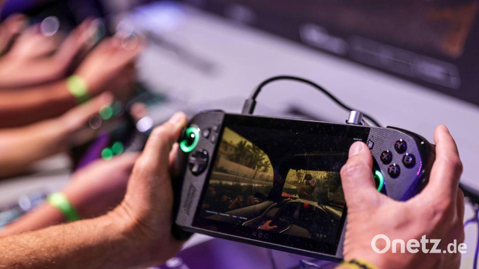 Ein Gamer hält bei der Gamescom 2025 ein Handheld-Device - eine Art tragbaren Mini-Gamingcomputer - in den Händen. (Archivbild) Bild: Oliver Berg/dpa