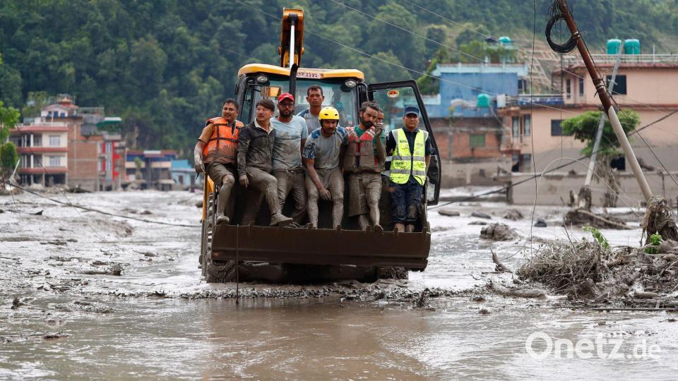 Einsatzkräfte retten nach einer Sturzflut im Distrikt Nuwakot in Nepal Menschen mit einer Planierraupe aus Gebäuden und der Infrastruktur, die entlang des angeschwollenen Trishuli-Flusses beschädigt wurden. Bild: Skanda Gautam/ZUMA Press Wire/dpa