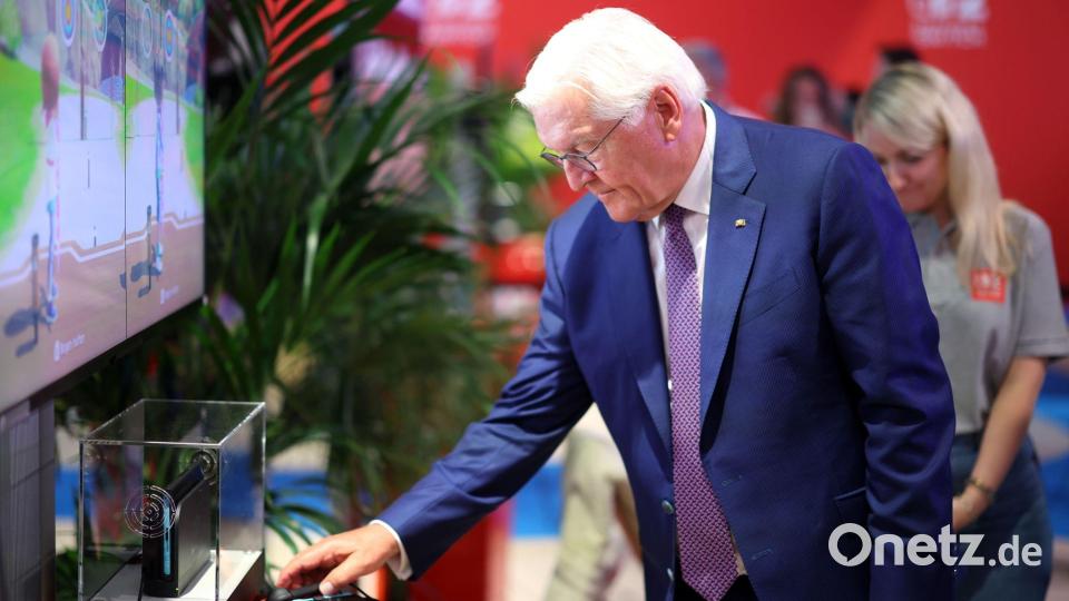 Steinmeier am Nintendo-Messestand, wo er digitales Bogenschießen als Sportart ausprobierte. Bild: Christoph Reichwein/dpa