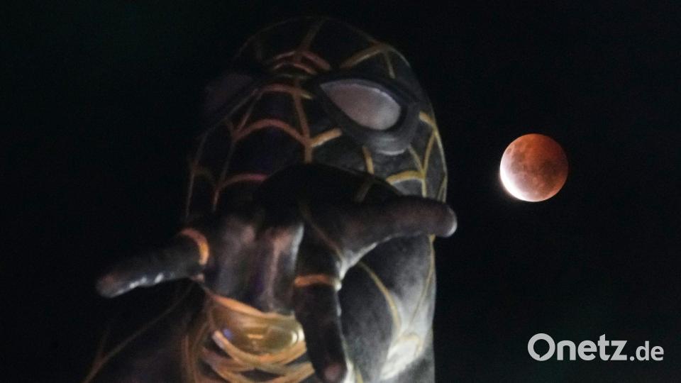 Während der partiellen Mondfinsternis geht in El Alto, Bolivien, der Mond hinter einer Spider-Man-Statue auf. Bild: Juan Karita/AP/dpa