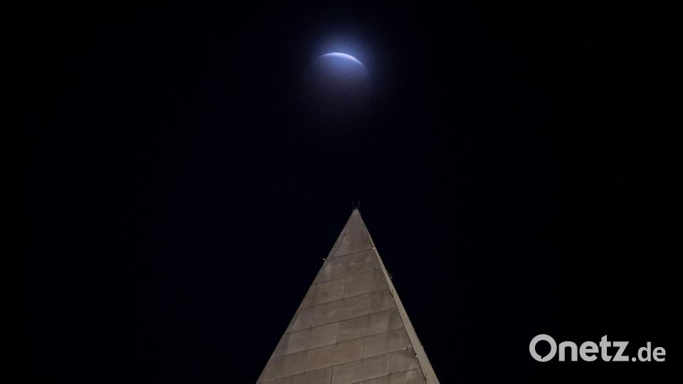 Hinter dem Washington-Monument in Washington ist die partielle Mondfinsternis durch die Wolken zu sehen. Bild: Cliff Owen/AP/dpa