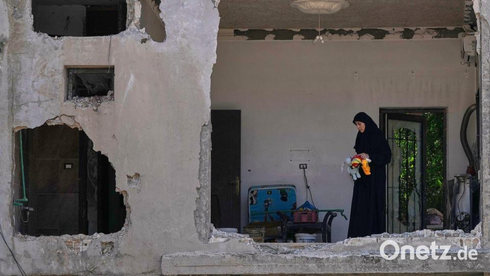 Eine Frau begutachtet ihr beschädigtes Haus an der Stelle einen Tag nach einem israelischen Luftangriff im Dorf Arab Salim im Südlibanon. Bild: Mohammed Zaatari/AP/dpa