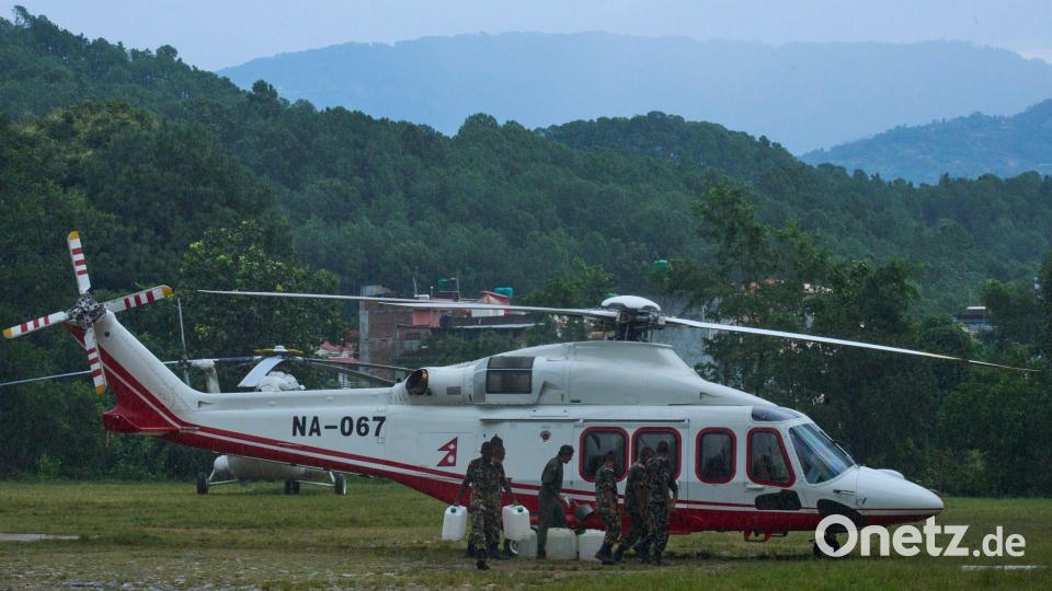 Soldaten der nepalesischen Armee betanken einen Hubschrauber, bevor dieser zu einem Rettungseinsatz nach den Sturzfluten abhebt. Bild: Niranjan Shrestha/AP/dpa