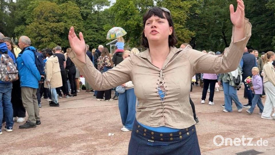Sonya Lii Nome Barlow singt auf dem Schlossplatz ein Lied zu Ehren von Harald V. Bild: Julia Wäschenbach/dpa