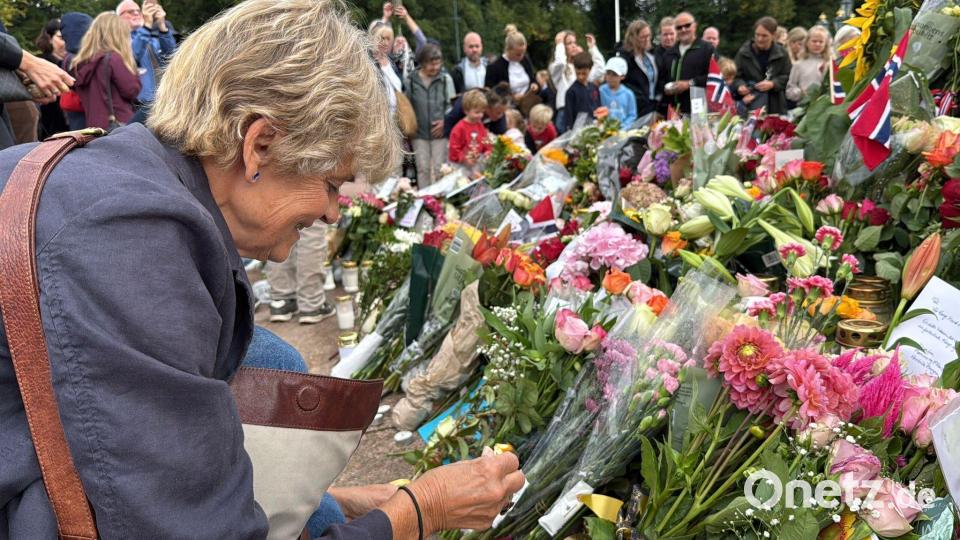 Anne Sandø Seierstad zündet eine Kerze für den gestorbenen Monarchen an. Bild: Julia Wäschenbach/dpa