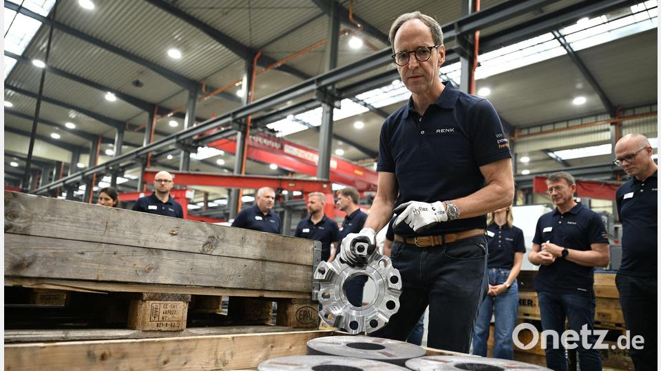 Renk-Manager Emmerich Schiller hält einen Planetenträger in der Hand, ein Bauteil für ein Panzergetriebe. Im Vordergrund sind 50 Kilo schwere Stahlscheiben zu sehen, aus denen der 15 Kilo schwere Planetenträger mit neuen Maschinen gefertigt wird. Bild: Wolf von Dewitz/dpa