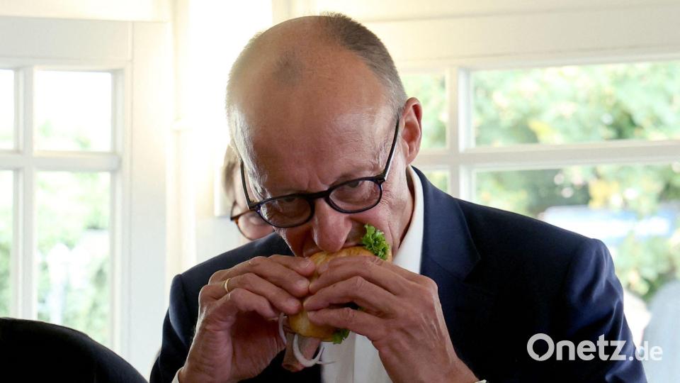 Das Fischbrötchen ließ sich der Kanzler schmecken. Bild: Bernd Wüstneck/dpa