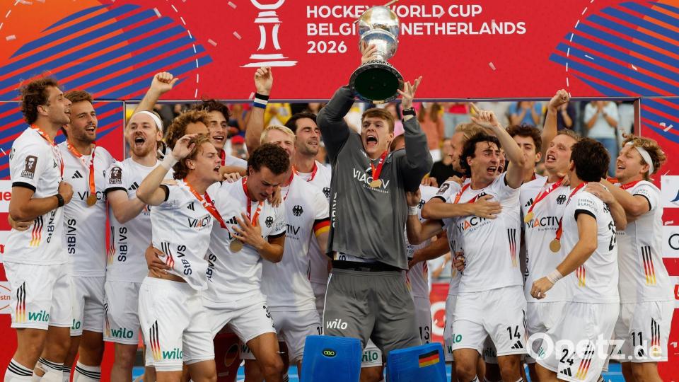 Die deutschen Hockeyspieler mit dem WM-Pokal. Bild: Geert Vanden Wijngaert/AP/dpa