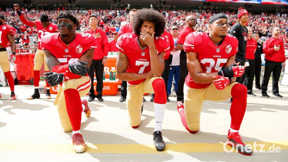 Colin Kaepernick (Mitte) kniend bei der Nationalhymne. Er bekam Unterstützung einiger Mitspieler, am Ende war es aber auch seine letzte Saison in der NFL. (Archivfoto) Bild: John G Mabanglo/EPA/dpa