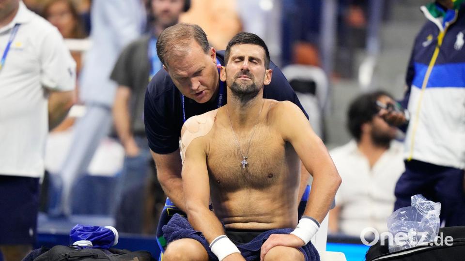 Novak Djokovic wird bei seinem Erstrundenaus am Rücken behandelt. Bild: Frank Franklin II/AP/dpa
