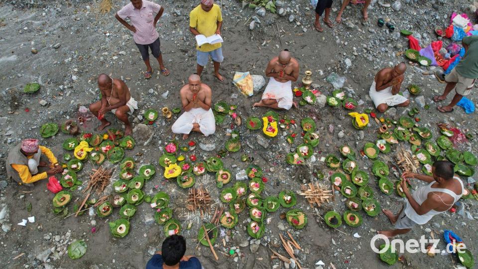 Menschen, deren Angehörige nach den Sturzfluten weiterhin vermisst werden, vollziehen am Ufer des angeschwollenen Trishuli-Flusses im nepalesischen Distrikt Nuwakot Rituale im Anschluss an symbolische Bestattungszeremonien. Bild: Rajesh Kumar Singh/AP/dpa