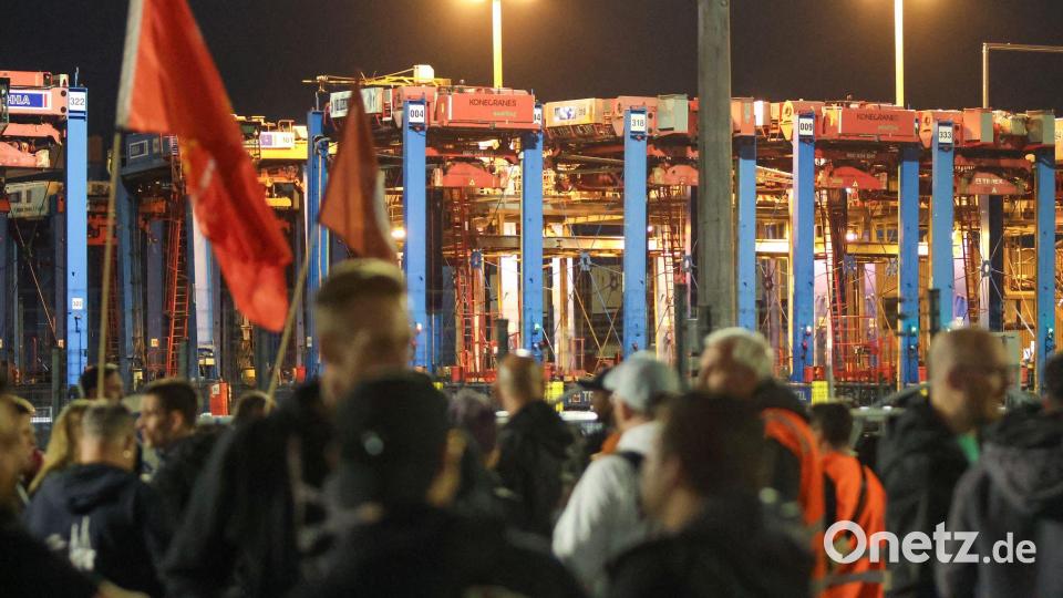 Mitarbeiter stehen im Rahmen eines Warnstreiks am Containerterminal Burchardkai (CTB) im Hamburger Hafen. Bild: Bodo Marks/dpa