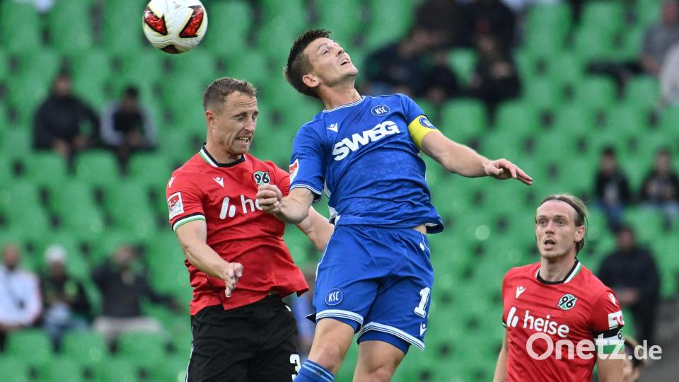 Im Kopfballduell: Karlsruhes Marvin Wanitzek (r) und Maurice Neubauer von Hannover 96. Bild: Swen Pförtner/dpa