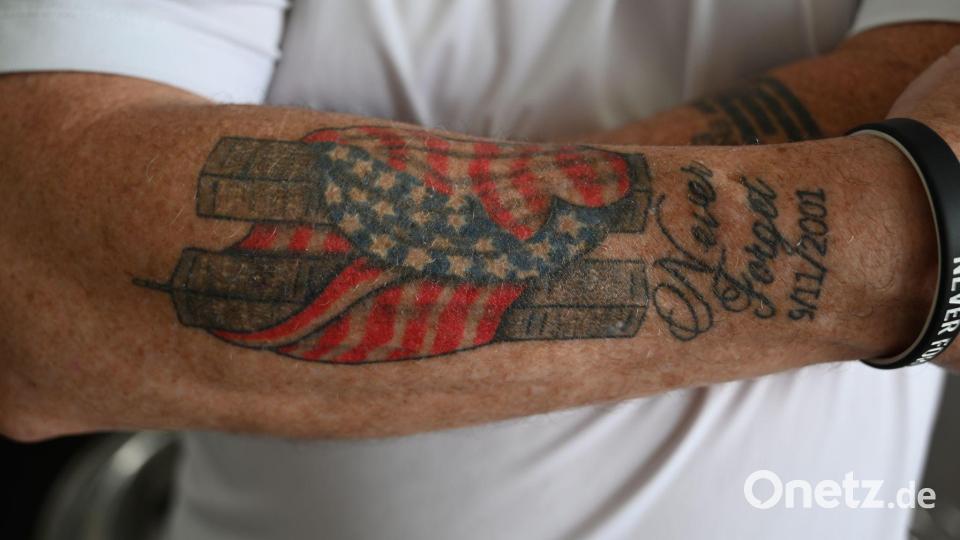 Es hat Jahre gebraucht, bis Feuerwehrmann Andrews sich nach 9/11 ein Bild der in eine amerikanische Flagge gehüllten Zwillingstürme auf den Unterarm tätowieren lassen konnte. Bild: Anne Pollmann/dpa