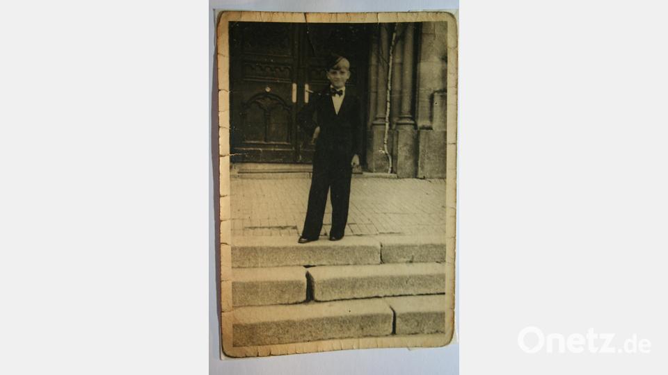 Ludwig Johann Krapf, „Hans“ genannt: Nach seiner Erstkommunion im Frühjahr 1943 steht er für ein Erinnerungsfoto vor dem Hauptportal der 1974 abgerissenen Pfarrkirche Mariä Himmelfahrt. Bild: gpa
