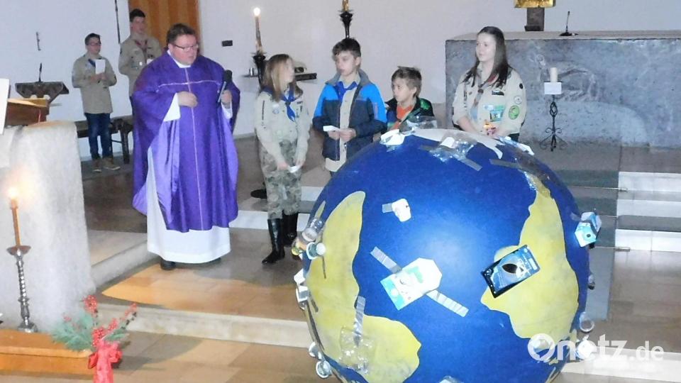Die Pfadfinder rufen im Gottesdienst zu Nachhaltigkeit auf. Dazu haben sie einen überdimensionierten vermüllten Erdball mitgebracht. Bild: hai