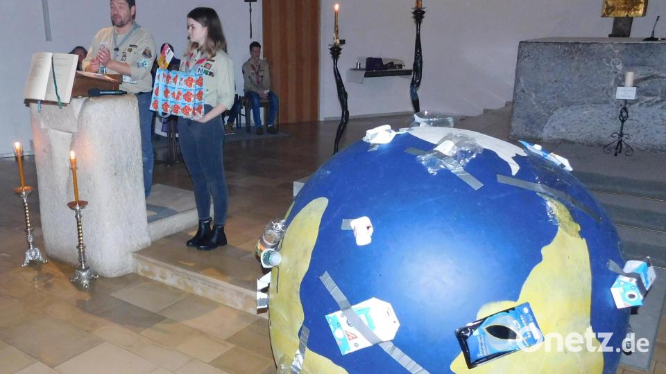 Die Pfadfinder rufen im Gottesdienst zu Nachhaltigkeit auf. Dazu haben sie einen überdimensionierten vermüllten Erdball mitgebracht. Bild: hai