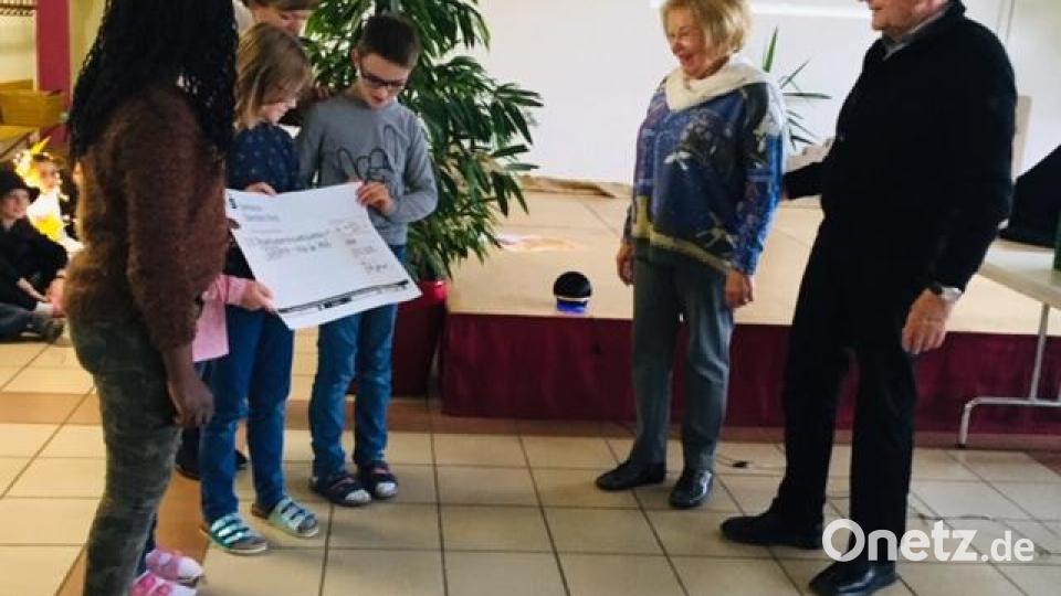 Die Kinder der Hammerweg-Grundschule übergeben einen Spendenscheck für das "Giriama-Projekt". Bild: exb