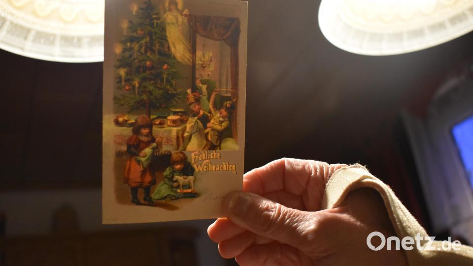 Auf dieser Karte erscheint erst im Schein des Lichtes das Christkind, welches die Gaben unter den Weihnachtsbaum legt. Die Kinder spielen mit ihren Geschenken. Mädchen haben Puppen und Holzspielzeug, die Jungen stellen mit Schwert, Pickelhaube und Pferd den Krieg nach. Bild: lue