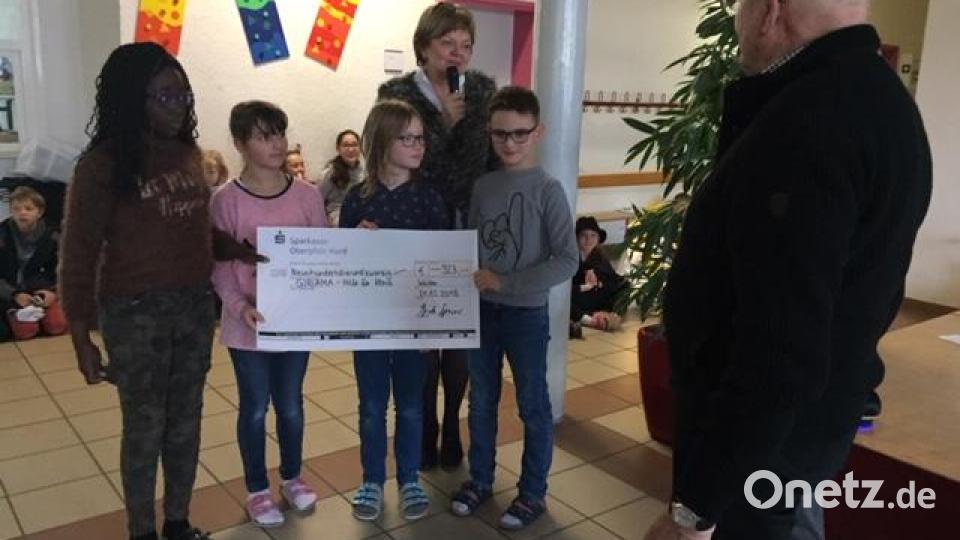 Die Kinder der Hammerweg-Grundschule übergeben einen Spendenscheck für das "Giriama-Projekt". Bild: exb