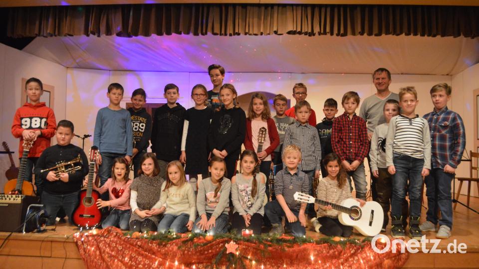 Mit einem kleinen Weihnachtskonzert erfreuten die Gitarren- und Trompetenschüler von Lehrer Benno Englhart (hinten re) die Besucher im Grafenwöhrer Jugendheim. Bild: myd