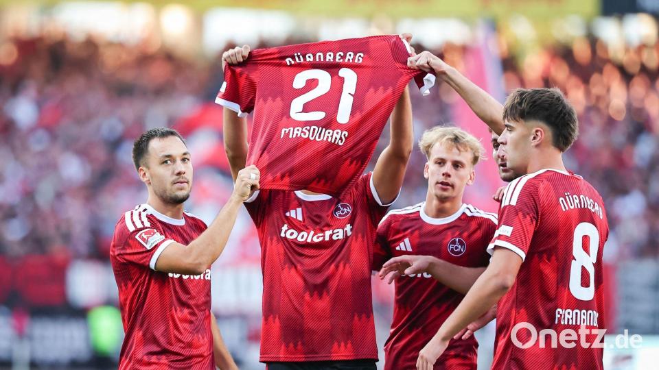 Besonderer Torjubel: Nach dem 1:0 halten Nürnbergs Profis das Trikot des fehlenden Kollegen Ioannis Masouras in die Höhe. Bild: Daniel Karmann/dpa