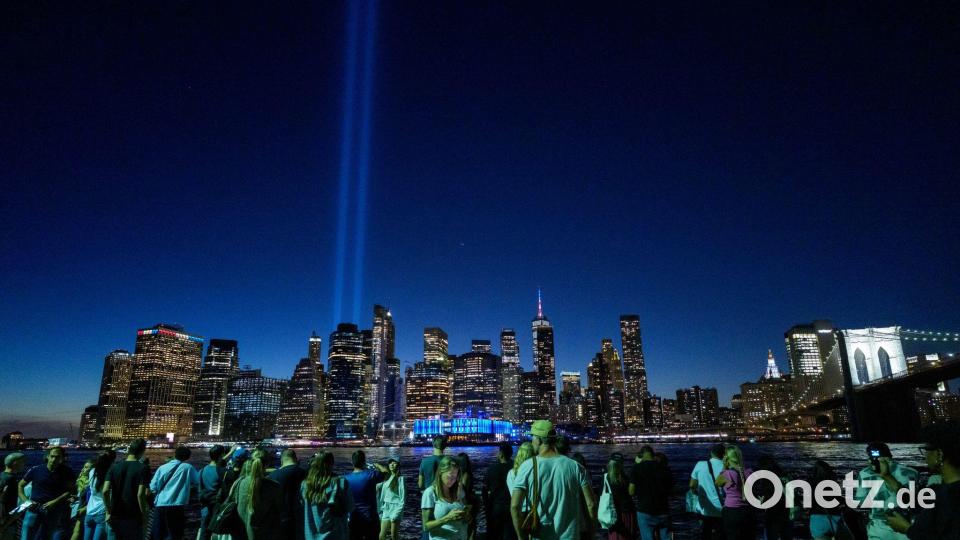 Menschen versammeln sich am 25. Jahrestag der Terroranschläge vom 11. September 2001 im New Yorker Stadtteil Brooklyn, um das Lichtspektakel „Tribute in Light“ zu beobachten, das über Lower Manhattan strahlt. Bild: Adam Gray/AP/dpa
