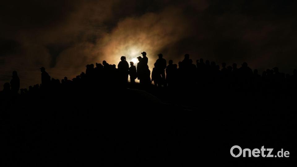 Die Sonne geht langsam unter, während Zuschauer beim Irish Open-Golfturnier auf dem Trump International Golf Links Ireland zusammenstehen. Bild: Julia Demaree Nikhinson/AP/dpa