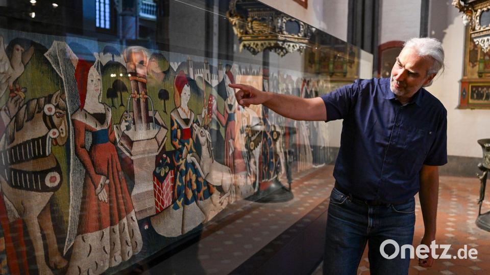 Pfarrer Philipp Mosch erklärt oft Besucherinnen und Besuchern seiner Kirche den Teppich. Bild: Jens Kalaene/dpa