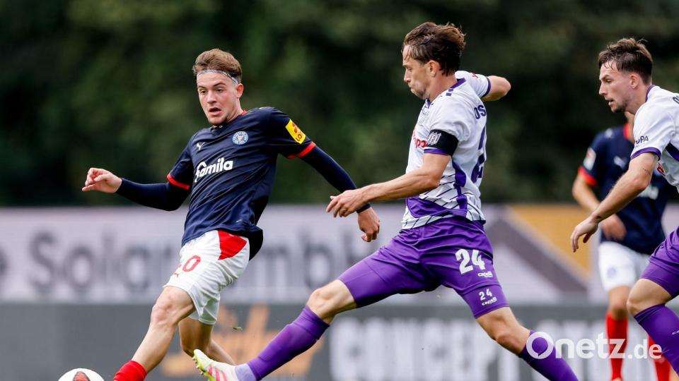 Leon Parduzi (l, Holstein Kiel) und Jannik Müller (VfL Osnabrück) kämpfen um den Ball. Bild: Philipp Szyza/dpa