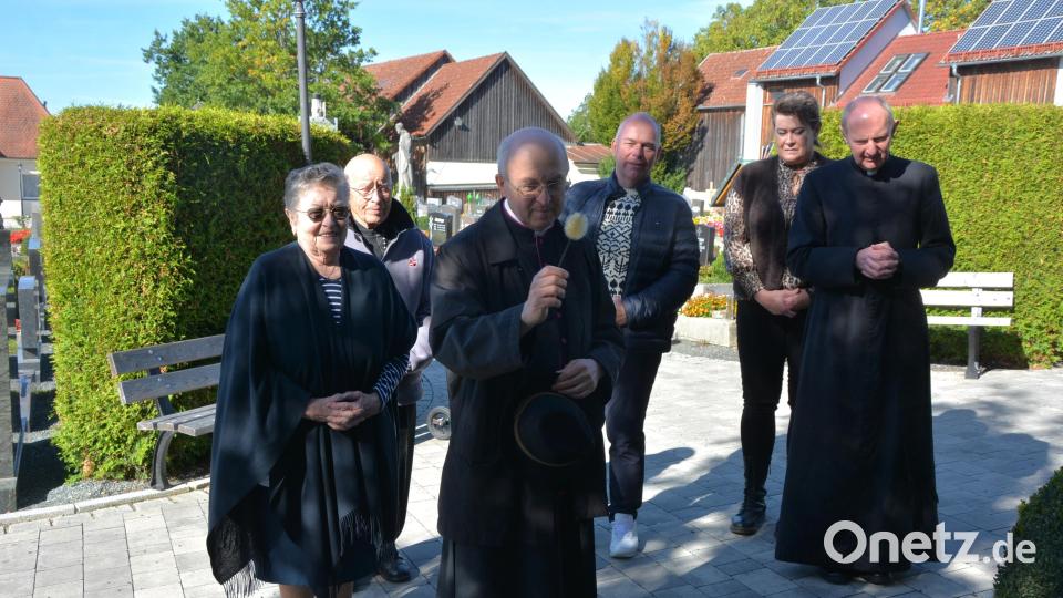 Am Samstagvormittag beteten Monsignore Georg Schwager und die Familie Janssen am Grab der Resl. Bild: Josef Rosner