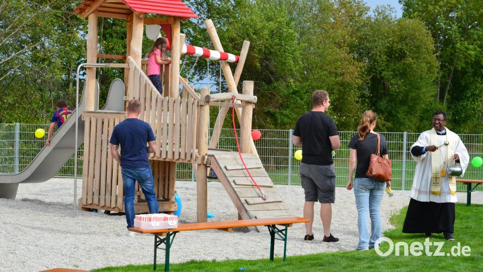 Pfarrer Celestine (rechts) besprengte die Spielgeräte mit Weihwasser und freute sich mit den Gästen über ein gelungenes Projekt. Lange zuvor schon hatten die Kinder ihr neues Domizil in Beschlag genommen. Bild: Wolfgang Houschka