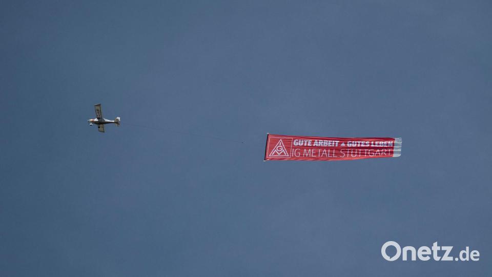Ein Flugzeug mit einem IG-Metall-Banner fliegt über das Porsche-Stammwerk in Zuffenhausen. Bild: Marijan Murat/dpa