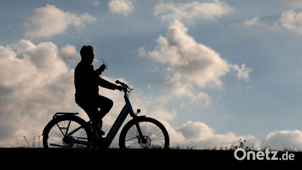 Ein Radfahrer ist mit seinem Fahrrad auf der Dammkrone des Stausees Kelbra unterwegs. Bild: Matthias Bein/dpa