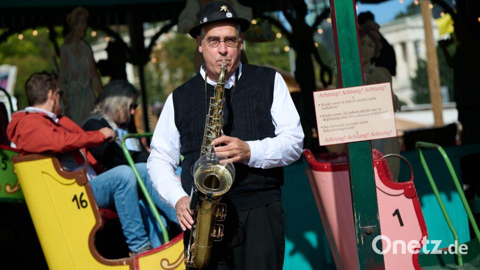 Gerne sorgt Toni Schleifer am Saxofon auch selbst für die passende Musik an seinem historischen Fahrgeschäft. Bild: Sven Hoppe/dpa